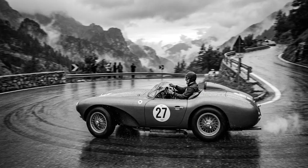 Auto storica in corsa su una strada di montagna